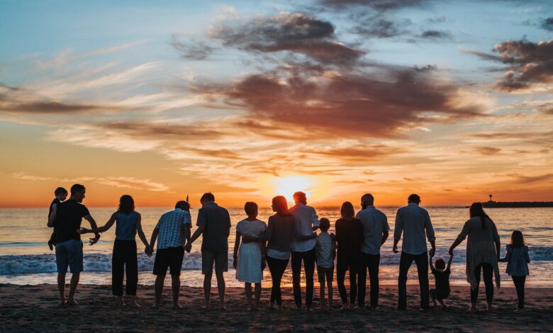 people standing on shore during golden hour